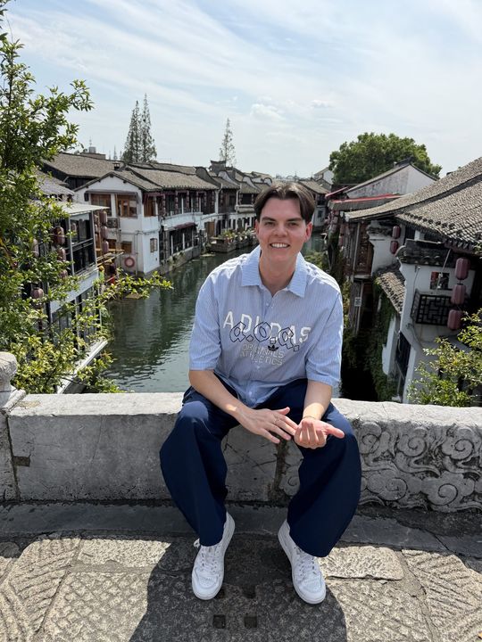 A traveller sitting on a stone bridge in a water town near Shanghai