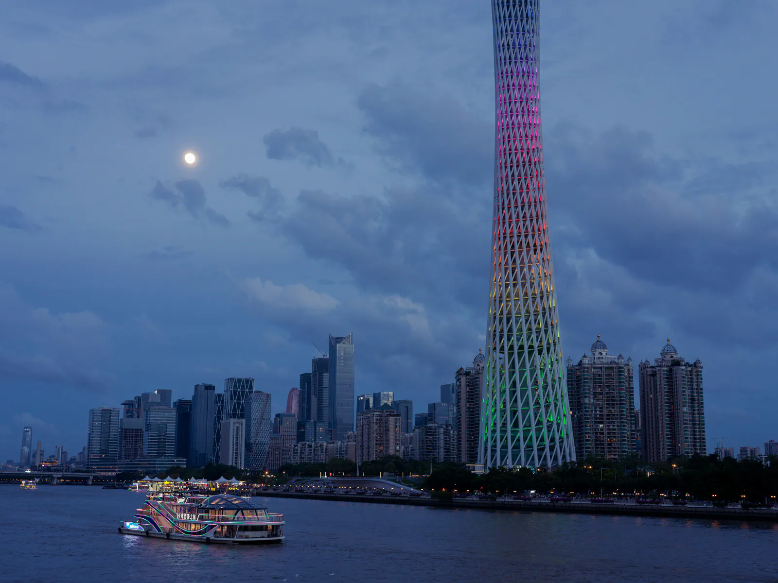 Canton Tower lit up at dusk beside the Pearl River