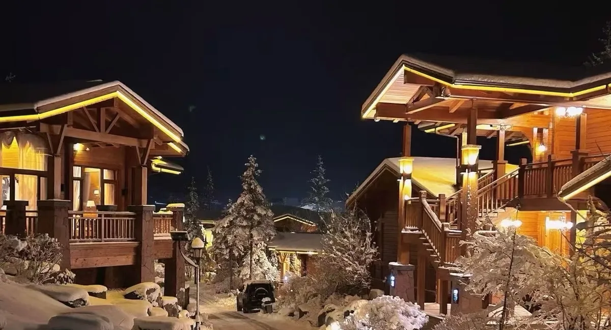 Snow-covered timber chalets glowing in a northern winter night