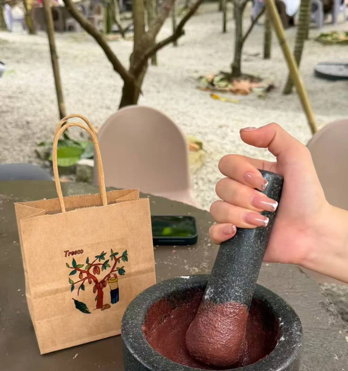 Hands grinding coffee at a Hainan coffee estate