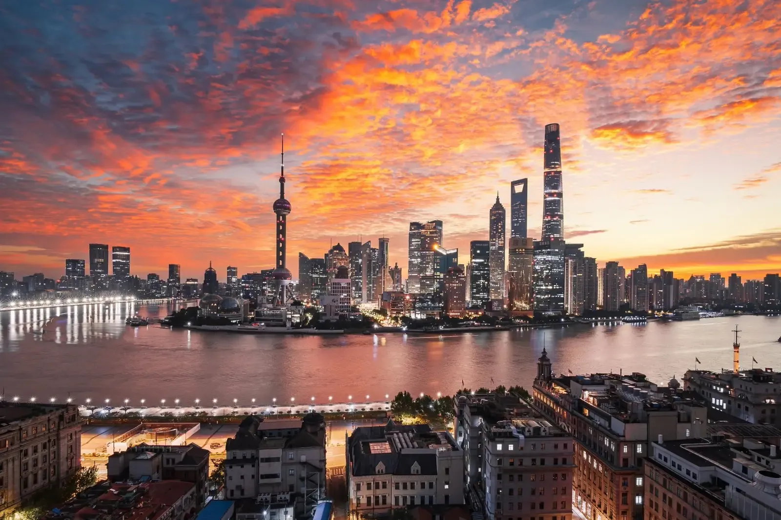 Shanghai skyline glowing beneath a dramatic sunset