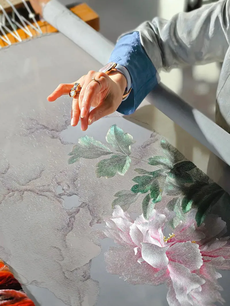 Artisan demonstrating detailed Suzhou silk embroidery